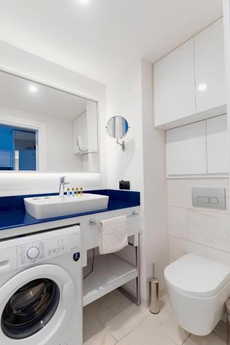 a white bathroom with a washing machine and a sink at Luxury Living Orbi City Batumi in Batumi