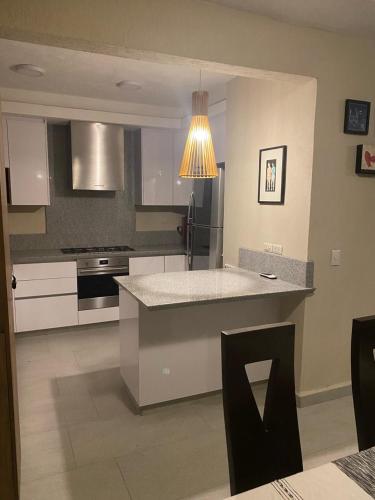 a kitchen with white cabinets and a light fixture at Casa Condo Diamante, Nueva Vallarta in Nuevo Vallarta