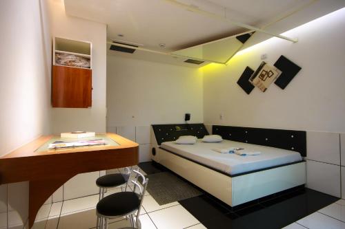 a small room with a bed and a desk at Hotel Kingite in Sao Paulo