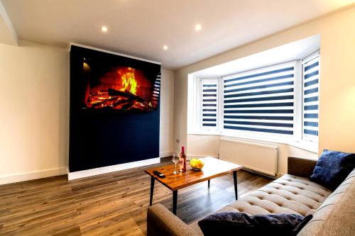 a living room with a couch and a fire on the wall at Blue Haven House Sleeps 11 Garden & Parking in Orgreave