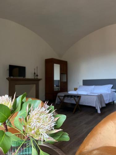 a bedroom with a bed and a table with flowers at Palazzo Cagianelli in Perugia