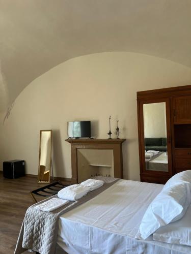 a bedroom with a white bed and a mirror at Palazzo Cagianelli in Perugia