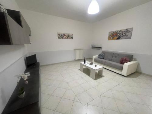 a living room with a couch and a coffee table at Red House- Accogliente appartamento vicino al porto in Civitavecchia