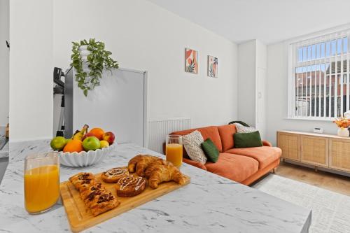 a table with a tray of food and orange juice at Stylish 4 Bed House In Chorley in Chorley