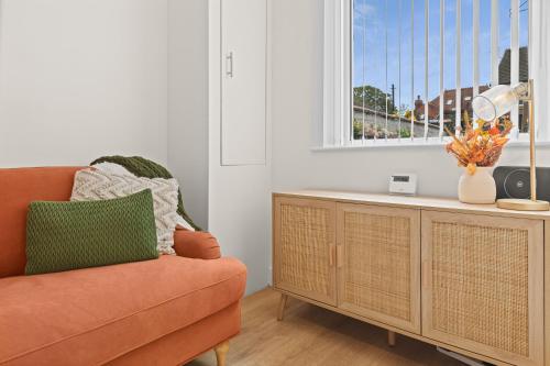 a living room with a orange couch and a window at Stylish 4 Bed House In Chorley in Chorley