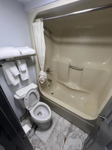 a bathroom with a toilet and a bath tub at Westowne Inn Paducah I-24 Exit 4 in Paducah