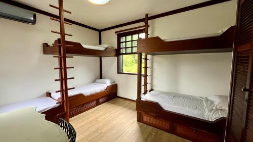 two bunk beds in a room with a window at Casa 02 Vale Boa Vista - Casa em Condomínio Exclusivo com Vista para as Montanhas e Área de Lazer Completa in Teresópolis