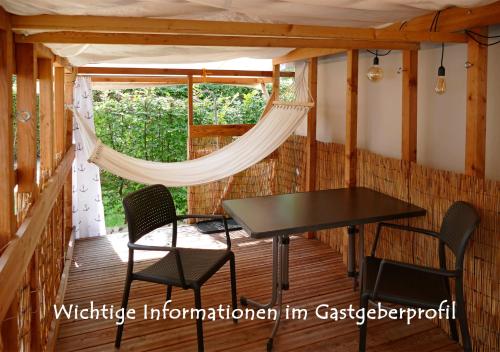 a screened in porch with a table and chairs at Refugio del Lago in Seekirchen am Wallersee