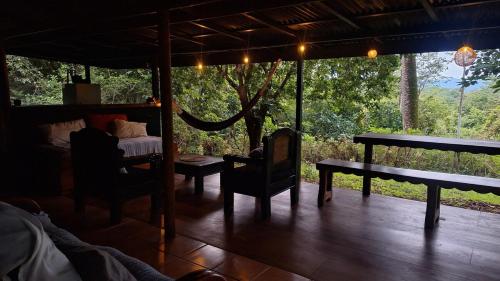 Habitación con porche con mesa y cama en Relaxing house in Montezuma, en Montezuma