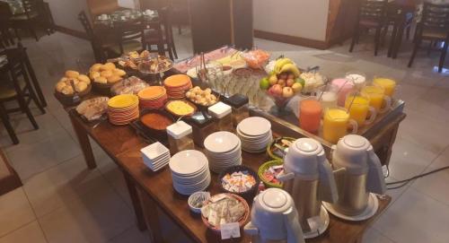 a table with a buffet of food and drinks at Anacã SC in São Carlos