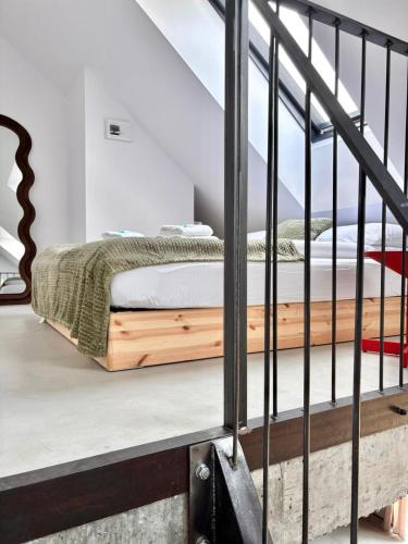 a bedroom with a bed on the stairs at Apartament WHITE GLOVE PARKYA LOFT in Olsztyn