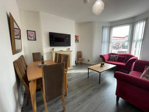 una sala de estar con una mesa y un sofá en The LFC Red House - Spacious House With 5 Bedrooms, 2 Bathrooms, Street Parking And 1 Minute From The Stadium, en Liverpool