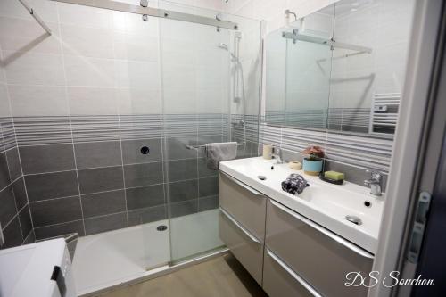 ein Badezimmer mit Dusche, Waschbecken und Spiegel in der Unterkunft Nest - Maison Rénovée, Parking gratuit, Fibre in Saintes