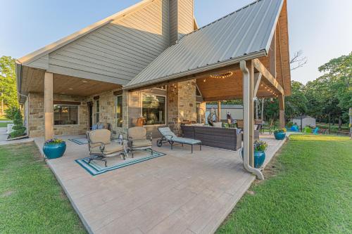 a covered patio with two chairs and a bar at Stunning Eufaula Waterfront Home in Dixie Cove 
