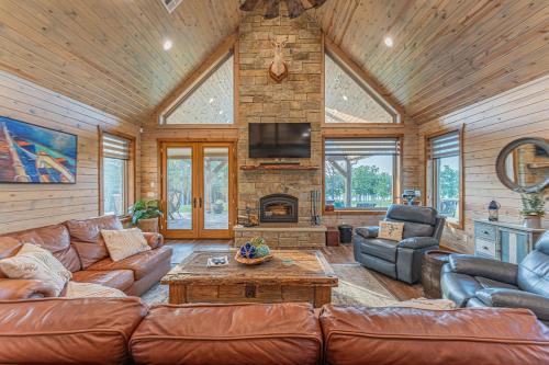 a living room with leather furniture and a fireplace at Stunning Eufaula Waterfront Home in Dixie Cove 