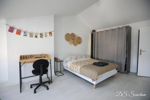 ein Schlafzimmer mit einem Bett, einem Schreibtisch und einem Stuhl in der Unterkunft Nest - Maison Rénovée, Parking gratuit, Fibre in Saintes