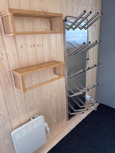 a room with a wooden wall with a refrigerator and shelves at Chalet Occursus Anzère in Anzère