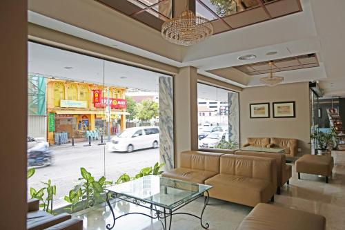 a living room with a couch and a glass table at Hotel Malaysia in George Town