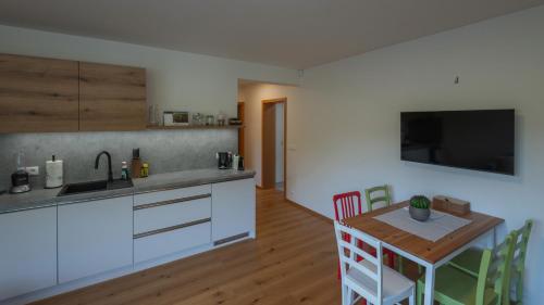 a kitchen with a table and a kitchen with white cabinets at Elements Chopok in Bystrá