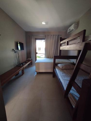 a bedroom with two bunk beds and a window at Condomínio Conchas e Corais in Barra Grande