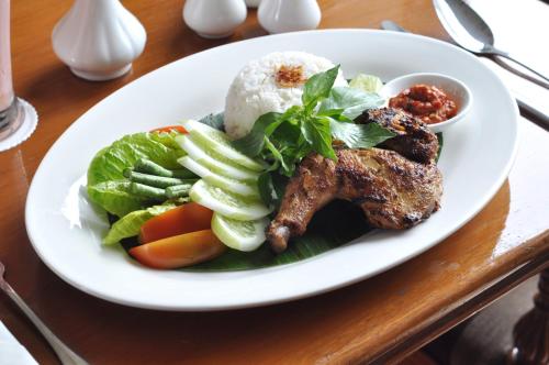 a plate of food with rice and vegetables on a table at Dreamtel Jakarta in Jakarta