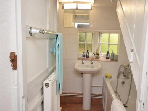 een witte badkamer met een wastafel en een bad bij 2 Bed in Brede 46895 in Brede