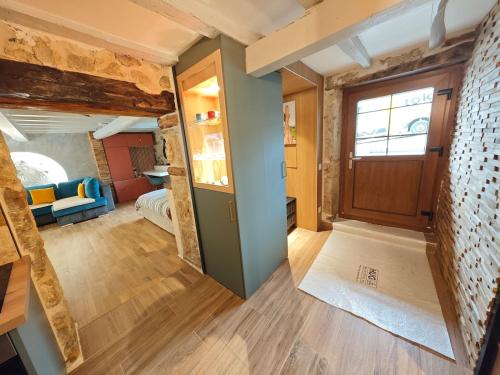 a room with a hallway with a door and a living room at Superbe Studio Roustique in Saint-Jean-de-Gonville