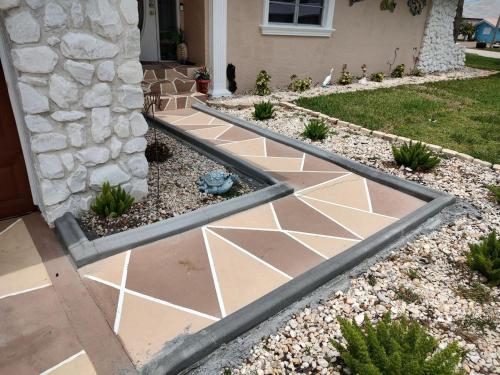 a garden with a stone walkway in front of a house at TheTotal Florida life style heated pool 5 bedrooms in Punta Gorda