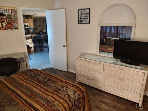 a bedroom with a dresser with a flat screen tv at TheTotal Florida life style heated pool 5 bedrooms in Punta Gorda