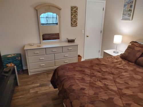 a bedroom with a bed and a dresser with a mirror at TheTotal Florida life style heated pool 5 bedrooms in Punta Gorda