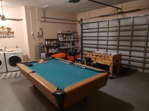 a room with a pool table in a garage at TheTotal Florida life style heated pool 5 bedrooms in Punta Gorda