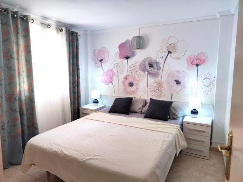 a bedroom with a bed with flowers on the wall at Villa SunShine Ciudad Quesada Spain in Ciudad Quesada