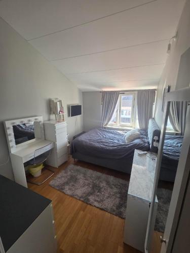 a bedroom with a bed and a desk and a window at The terraced house in Stockholm