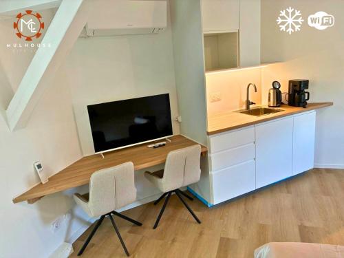 a kitchen with a desk with a tv and a sink at Mulhouse City Loft in Mulhouse