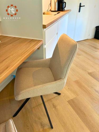 a chair sitting in front of a wooden table at Mulhouse City Loft in Mulhouse