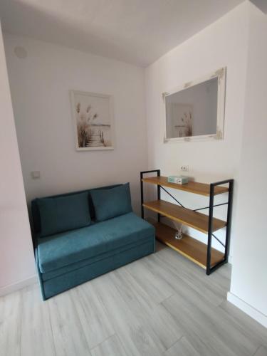 a living room with a blue couch and a table at Studio Vata in Vaţa de Jos