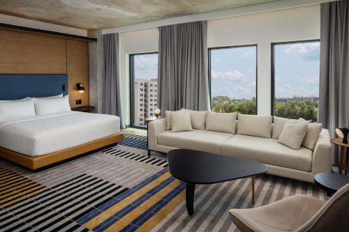 a hotel room with a bed and a couch at Canopy By Hilton Nashville Downtown The Gulch in Nashville