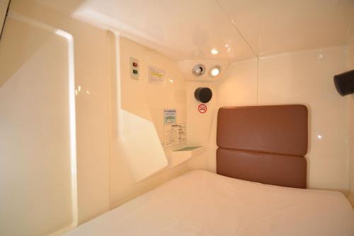 En eller flere senge i et værelse på Capsule&Spa Grand Sauna Shinsaibashi