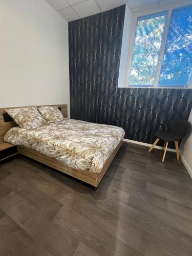 une chambre avec un lit et une chaise dedans dans l'établissement La Récré, à Mortagne-sur-Sèvre