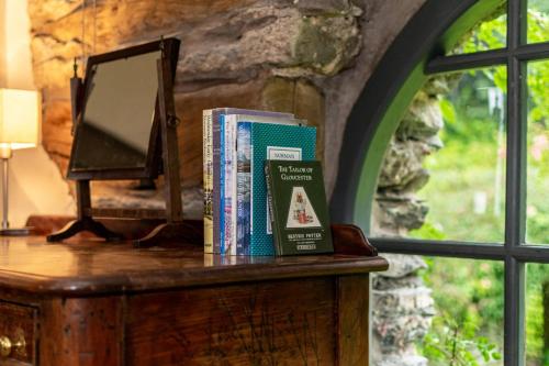 a stack of books sitting on a table next to a mirror at The Chapel in Silecroft