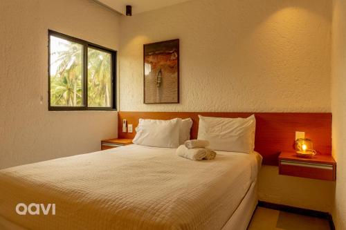 ein Schlafzimmer mit einem Bett, auf dem ein Stofftier liegt in der Unterkunft Villa Kamby na Rota Ecológica dos Milagres by Qavi in São Miguel dos Milagres