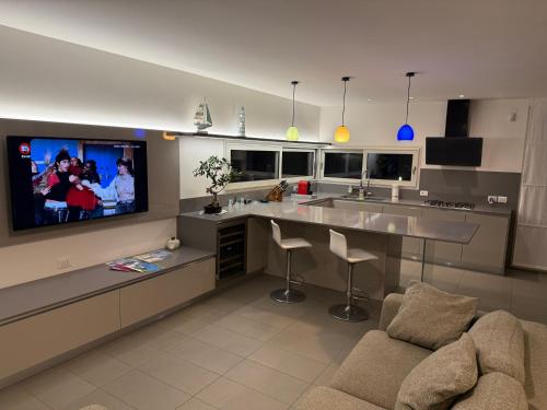 a kitchen with a flat screen tv on the wall at Villa Pinewood in Lignano Sabbiadoro