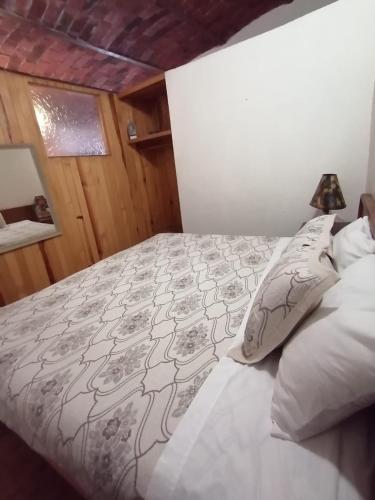 a bedroom with a bed with a comforter and pillows at Htl & Villas Las Glorias Mazamitla, céntricas, parking, jardín in Mazamitla