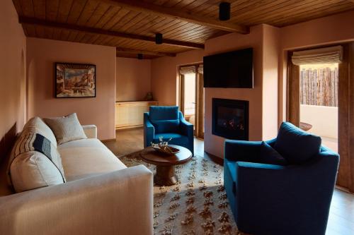 a living room with a couch and chairs and a fireplace at Hotel Willa in Taos