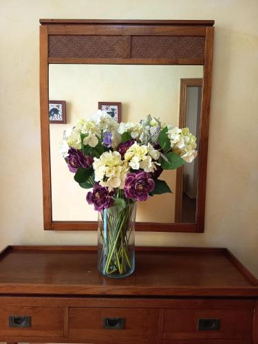 a vase of flowers on a dresser in front of a mirror at La Senia in Moncófar