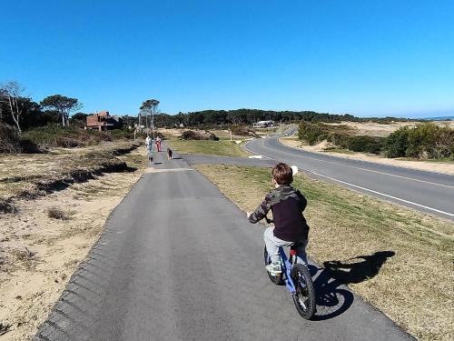 a young boy riding a bike down a road at La Bonita Suites Punta Colorada in Punta Colorada