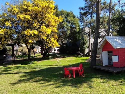 two red chairs and a red shed in a yard at La Bonita Suites Punta Colorada in Punta Colorada
