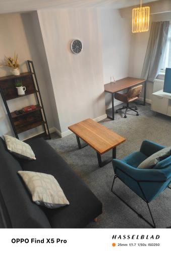 a living room with a bed and a table and a chair at Stunning maisonette available in Watford
