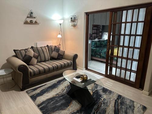 a living room with a couch and a glass table at Kiwara Guesthouse in Johannesburg