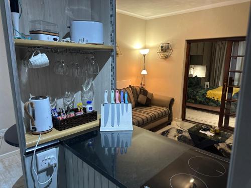 a kitchen with a living room with a couch at Kiwara Guesthouse in Johannesburg